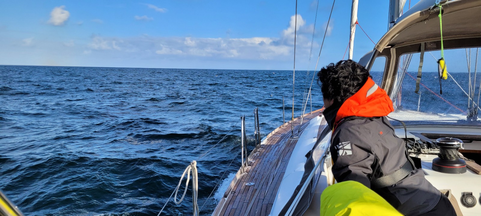 Une personne regarde au loin en voilier